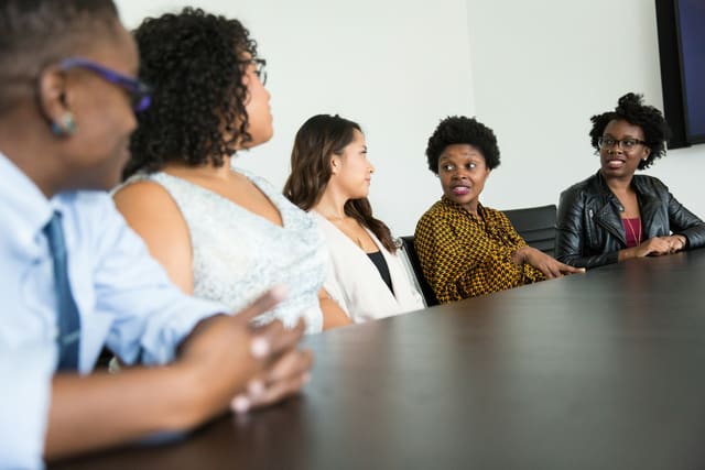 Groep mensen in gesprek aan een tafel